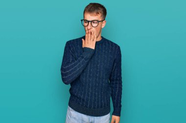 Sıradan kıyafetler ve gözlük takan genç sarışın adam ağzıyla ağzını kapatmaktan sıkılmış. Huzursuz ve uykulu.. 