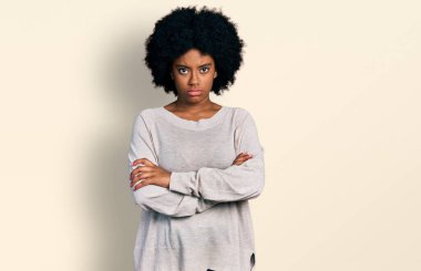 Gündelik kıyafetler giyen, kuşkucu ve gergin genç Afro-Amerikalı bir kadın. Yüzünde çapraz kollarla onaylamayan bir ifade var. negatif kişi. 
