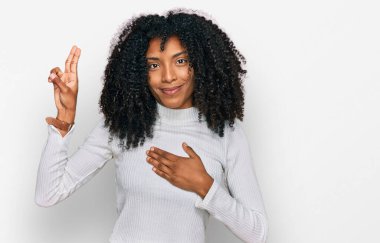 Genç Afro-Amerikan kızı, günlük giysiler giymiş, gülümsüyor, elleri göğsünde ve parmakları havada küfür ediyor, sadakat yemini ediyor. 