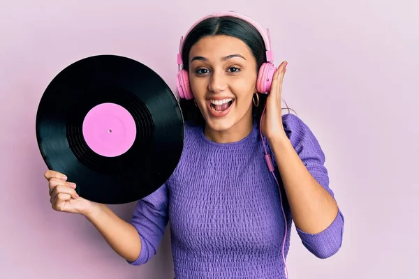 Jovem Hispânica Usando Fones Ouvido Segurando Disco Vinil Celebrando Louco — Fotografia de Stock