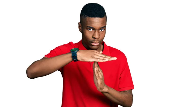 若いアフリカ系アメリカ人の男を着てカジュアルな赤いTシャツを手でタイムアウトジェスチャーを行います フラストレーションと深刻な顔 — ストック写真