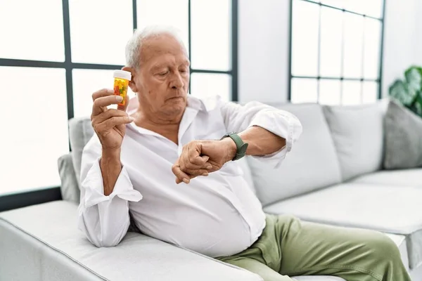 Uomo Anziano Possesso Pillole Controllando Tempo Sull Orologio Polso Rilassato — Foto Stock