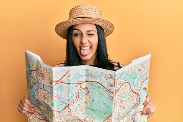 Jovem Hispânica Usando Chapéu Verão Segurando Mapa Furando Língua Feliz — Fotografia de Stock