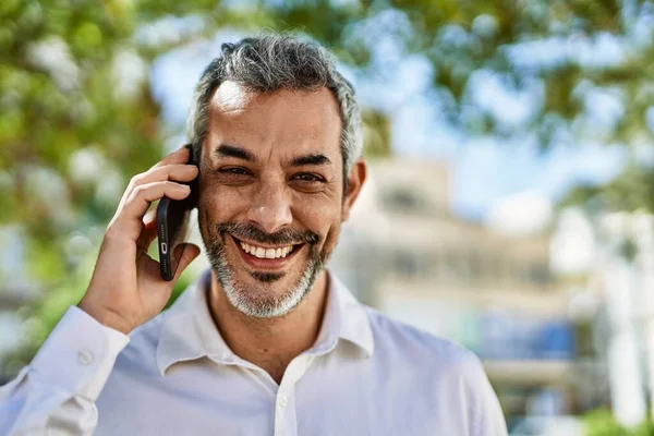 Medelålders Gråhårig Man Ler Glad Prata Smartphone Staden — Stockfoto