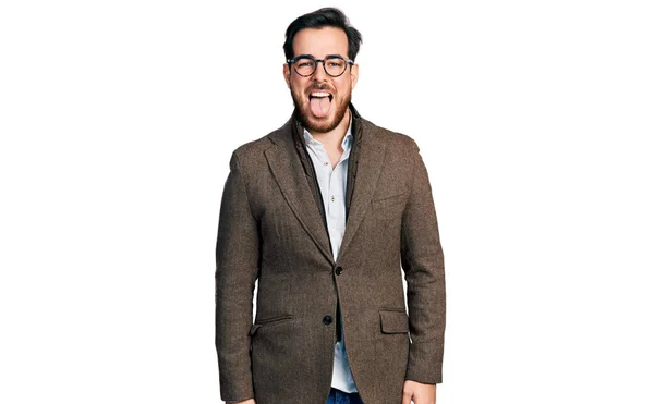 ビジネスジャケットを着た若いヒスパニック系の男と面白い表情で幸せ舌を突き出す眼鏡 感情の概念 — ストック写真