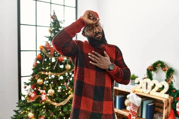 Afrikanischer Mann Mit Weihnachtsmannmütze Der Weihnachtsbaum Steht Und Die Stirn — Stockfoto