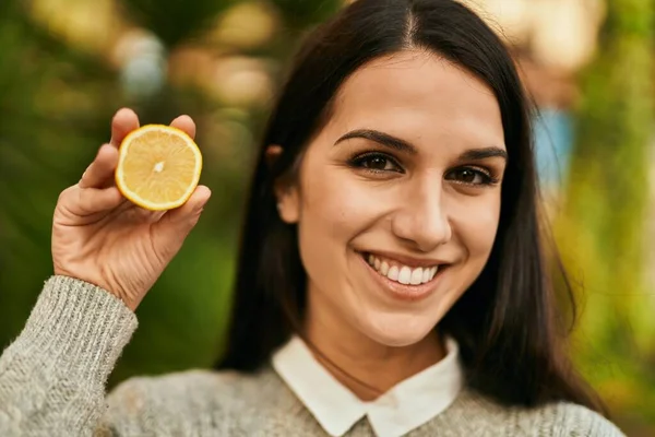 若いですヒスパニック系の女性笑顔幸せな保持レモンのスライスで街 — ストック写真