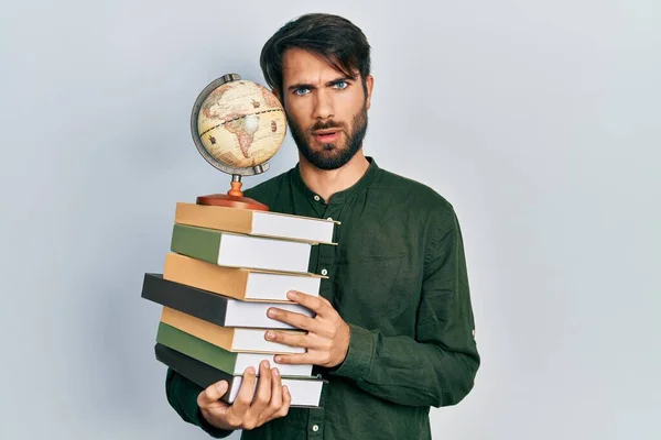 Молодий Іспаномовний Чоловік Тримає Книги Світовий Шоковому Обличчі Виглядає Скептично — стокове фото