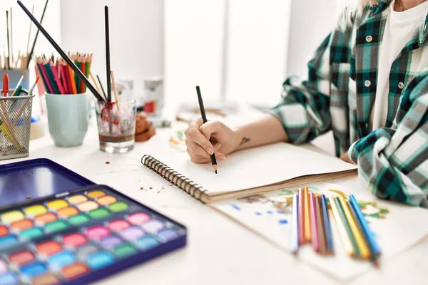 アートスタジオで机の上に座っているアーティストの学生の女の子 — ストック写真