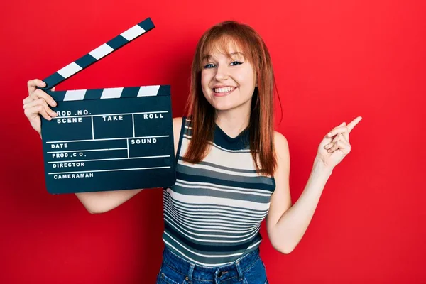 Vöröshajú Fiatal Kezében Videofilm Clapboard Mosolyogva Boldog Mutató Kéz Ujj — Stock Fotó
