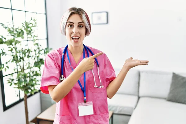 Jovem Mulher Bonita Vestindo Uniforme Médico Estetoscópio Espantado Sorrindo Para — Fotografia de Stock