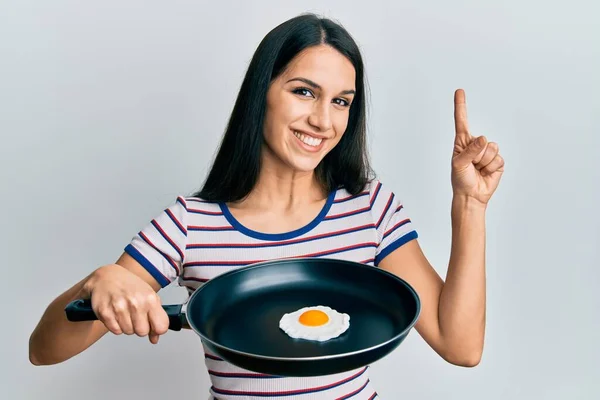 Genç Spanyol Kadın Elinde Sahanda Yumurtayla Gülümseyerek Bir Fikir Soruyla — Stok fotoğraf
