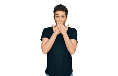 Gündelik siyah tişört giyen genç yakışıklı adam yanlışlıkla elleriyle ağzını kapatırken şok oldu. gizli kavram. 