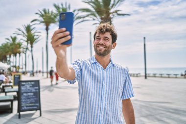 Genç İspanyol adam güvertede mutlu bir şekilde gülümsüyor..