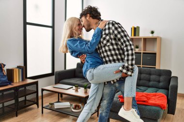 Gülümseyen genç çift evde mutlu dans ediyor..