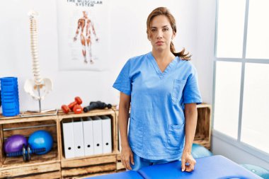 Orta yaşlı İspanyol fizyoterapist kadın ağrı kesici kliniğinde çalışıyor şüpheci ve gergin, sorun yüzünden surat asıyor. negatif kişi. 