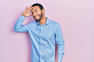 Sakallı, sıradan mavi tişörtlü, mutlu ve tebessüm eden İspanyol bir adam. arama kavramı. 