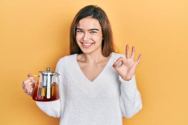 Kafkasyalı genç bir kız elinde çay kavanozu tutuyor. Parmaklarıyla imza atıyor, gülümsüyor. Mükemmel bir sembol. 