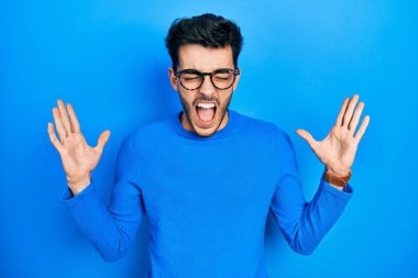 Gündelik kıyafetler ve gözlük takan genç İspanyol adam başarının çılgınlığını kutluyor. Kolları havada ve gözleri kapalı, heyecanlı çığlıklar atıyorlar. Kazanan konsept 