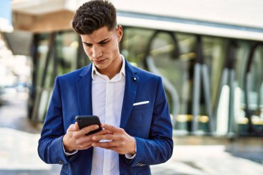 Sokakta akıllı telefon kullanan genç bir adam.