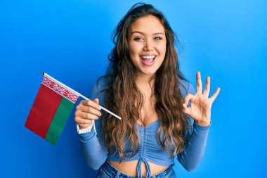 Beyaz bayrak tutan İspanyol genç kız parmaklarıyla imza atıyor, gülümseyerek mükemmel bir sembol oluşturuyor. 