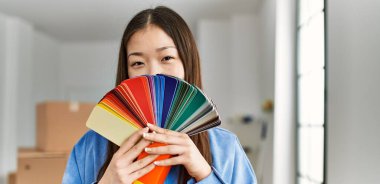 Genç Çinli kız yeni evinde ağzını renk testiyle kapatıyor..