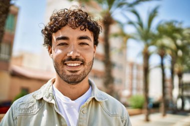 Yakışıklı, sakallı, güneşli bir günde mutlu bir şekilde gülümseyen bir İspanyol.