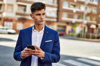 Sokakta akıllı telefon kullanan genç bir adam.