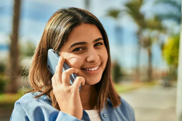 若いですラテン語の女の子笑顔幸せな話上のスマートフォンで街 — ストック写真