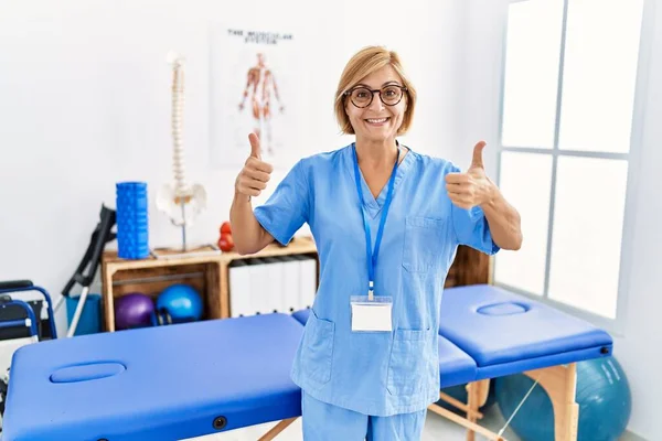 Orta Yaşlı Sarışın Kadın Ağrı Kesici Kliniğinde Çalışıyor Başarı Işareti — Stok fotoğraf