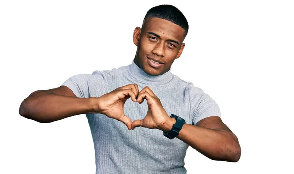 愛の心のシンボルの形を手で行う笑顔でカジュアルなTシャツを着て若い黒人男性 ロマンチックなコンセプト — ストック写真