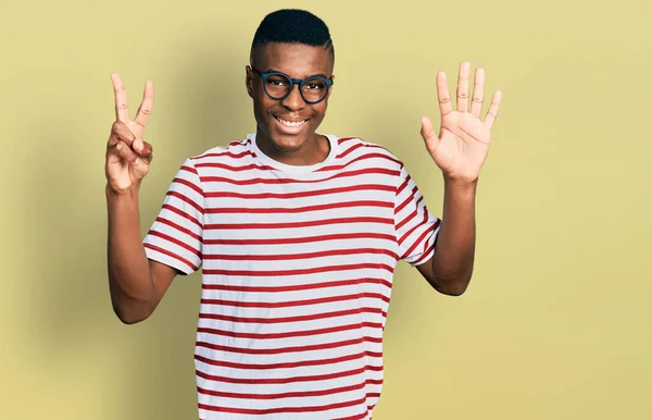 年轻的非洲裔美国人 身穿休闲装 戴着眼镜 带着七号手指 面带微笑 自信而快乐 — 图库照片