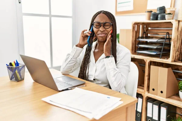 Чорна Жінка Косами Працює Офісі Розмовляючи Телефону Торкаючись Рота Рукою — стокове фото