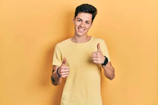 Молодий Іспаномовний Чоловік Одягнений Жовту Сорочку Знак Успіху Роблячи Позитивний — стокове фото