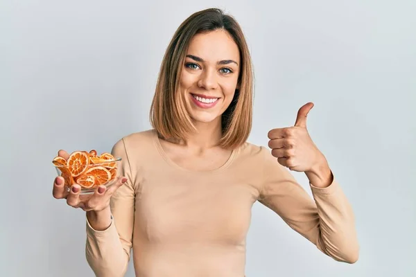 Joven Mujer Rubia Caucásica Sosteniendo Tazón Naranja Seca Sonriendo Feliz — Foto de Stock