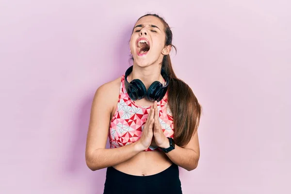 Joven Adolescente Morena Vestida Con Ropa Gimnasio Usando Auriculares Mendigando —  Fotos de Stock