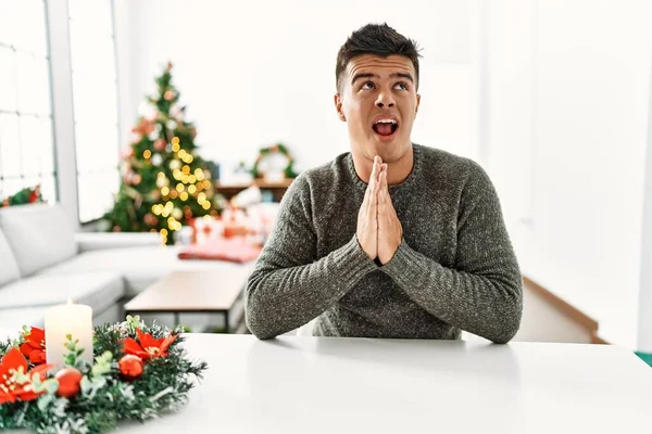 Junger Hispanischer Mann Sitzt Auf Dem Tisch Weihnachtsbaum Und Bettelt — Stockfoto