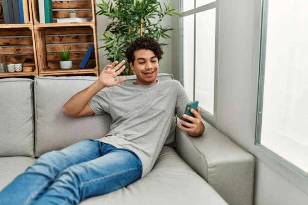 Evdeki Kanepede Oturan Latin Asıllı Genç Adam Akıllı Telefon Kullanıyor — Stok fotoğraf