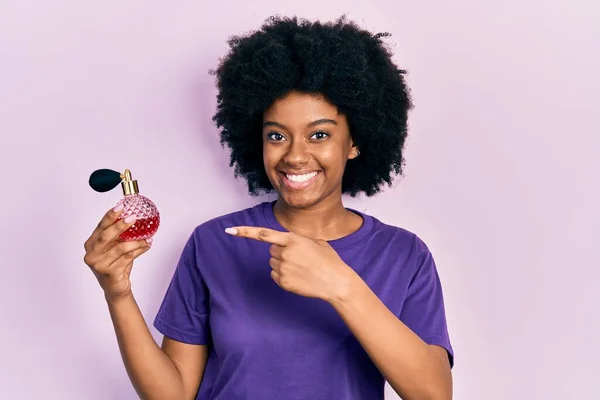 Joven Mujer Afroamericana Sosteniendo Perfume Sonriendo Feliz Señalando Con Mano — Foto de Stock