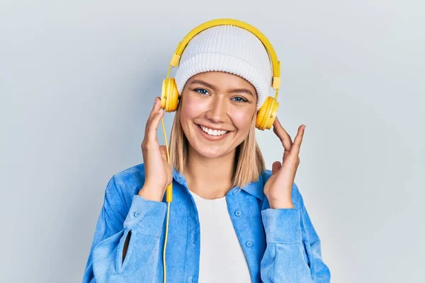 Όμορφη Ξανθιά Γυναίκα Ακούγοντας Μουσική Χρησιμοποιώντας Ακουστικά Που Φαίνονται Θετικά — Φωτογραφία Αρχείου