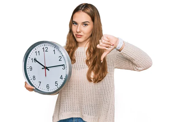 Giovane Donna Bionda Possesso Grande Orologio Con Faccia Arrabbiata Segno — Foto Stock