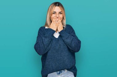 Günlük kıyafetler giyen, gülen, utanan, ağzı ellerle kapatan, dedikodu ve skandal konsepti olan genç beyaz bir kadın. 