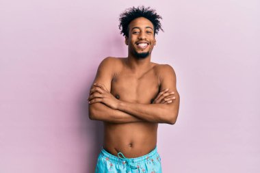 Sakallı, mayo giymiş, kollarını kavuşturup kameraya gülümseyen Afro-Amerikan genç adam. pozitif kişi. 