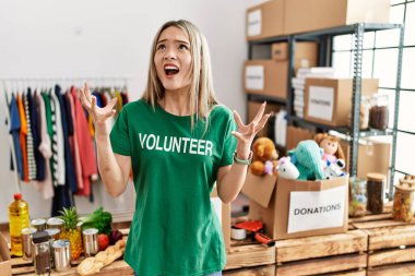 Bağışlarda gönüllü tişört giyen Asyalı genç bir kadın deli gibi bağırıyor ve agresif bir ifade ve kollarla bağırıyor. hüsran kavramı. 