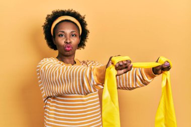 Genç Afro-Amerikalı kadın spor giysisi ve kol bandı takmış kameraya bakıyor ve öpüşüp koklaşıyor. aşk ifadesi. 