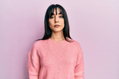 Kâküllü, kışlık süveter giyen genç esmer kadın yüzünde ciddi bir ifadeyle rahatladı. Basit ve doğal bir şekilde kameraya bakıyorsun.. 