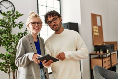 Ofiste dizüstü bilgisayarla çalışırken gülümseyen iki iş adamı.