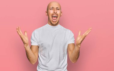 Dazlak, beyaz tişörtlü, kel bir adam deli gibi bağırıyor ve agresif bir ifade ve kollarla bağırıyor. hüsran kavramı. 