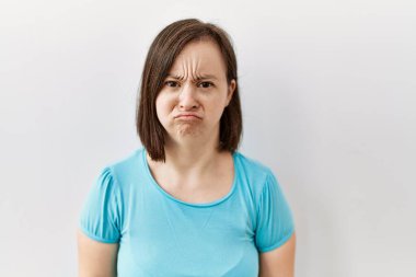 Genç Down sendromlu kadın yalnız başına ayakta duruyor. Depresyonda ve endişe içinde. Kızgın ve korkmuş bir şekilde ağlıyor. Üzücü ifade. 
