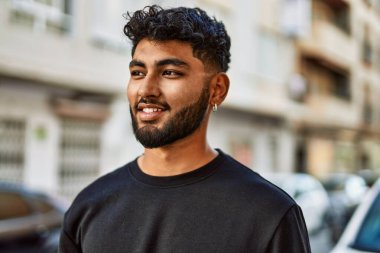 Sokakta kendinden emin gülümseyen genç bir Arap.